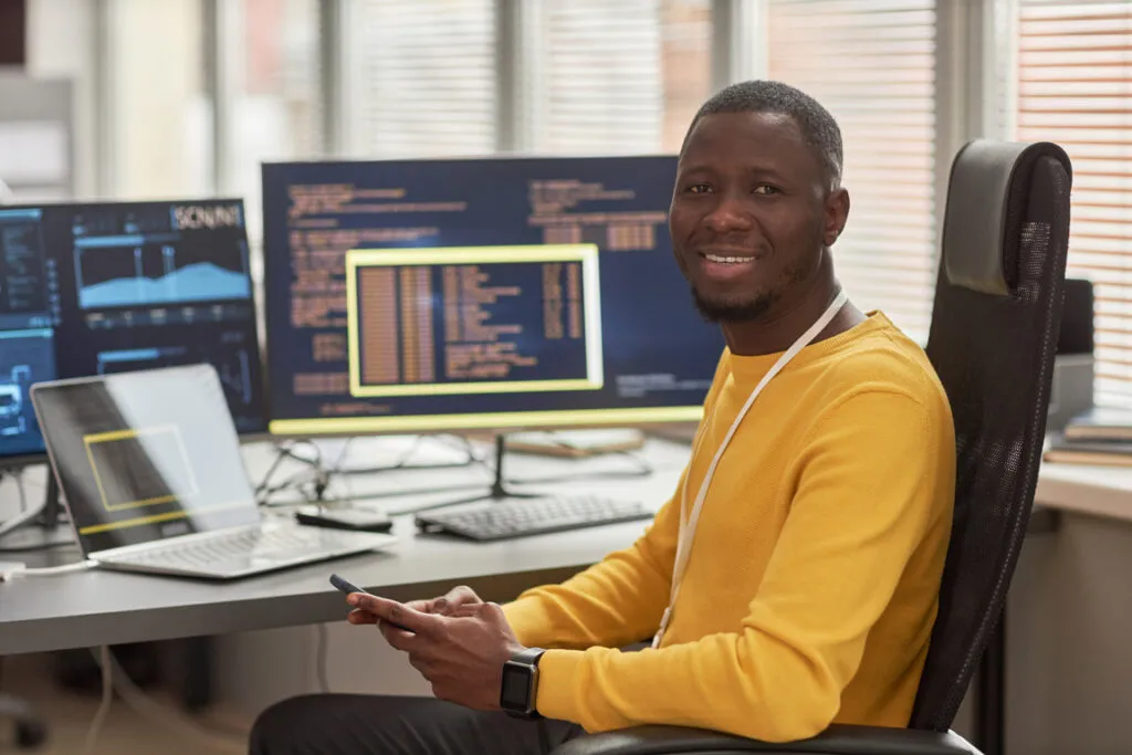 Software developer working at a code-filled workstation